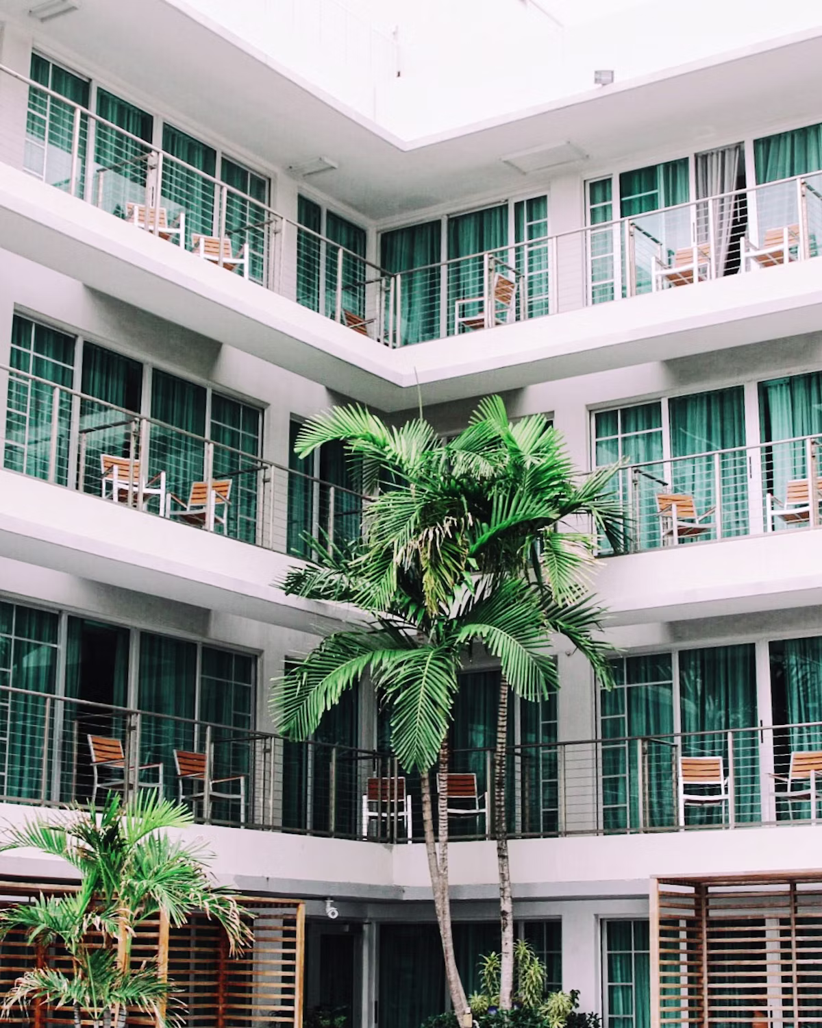 The Velvet Crest building exterior framed by tropical greenery