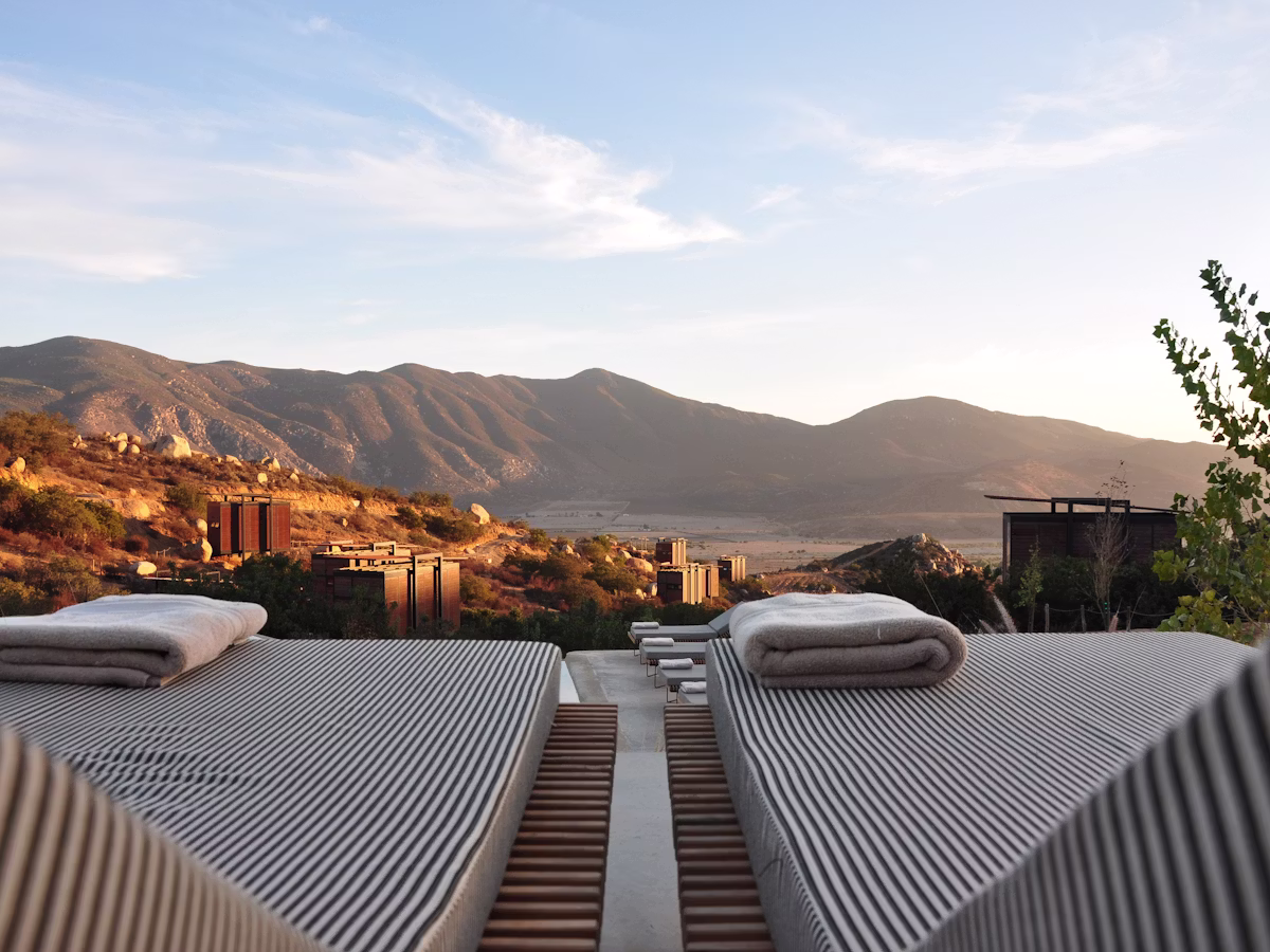 Private balcony with loungers overlooking distant hills at golden hour