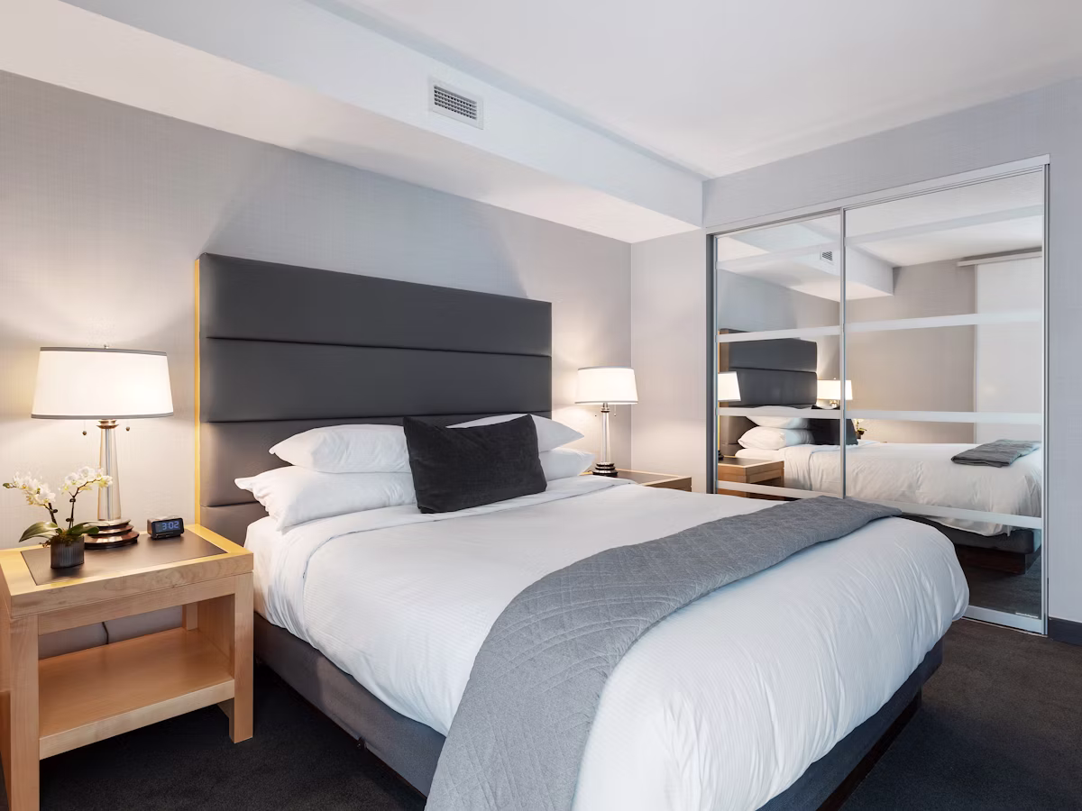 Bright twin-bed room with crisp white linen and a contemporary headboard