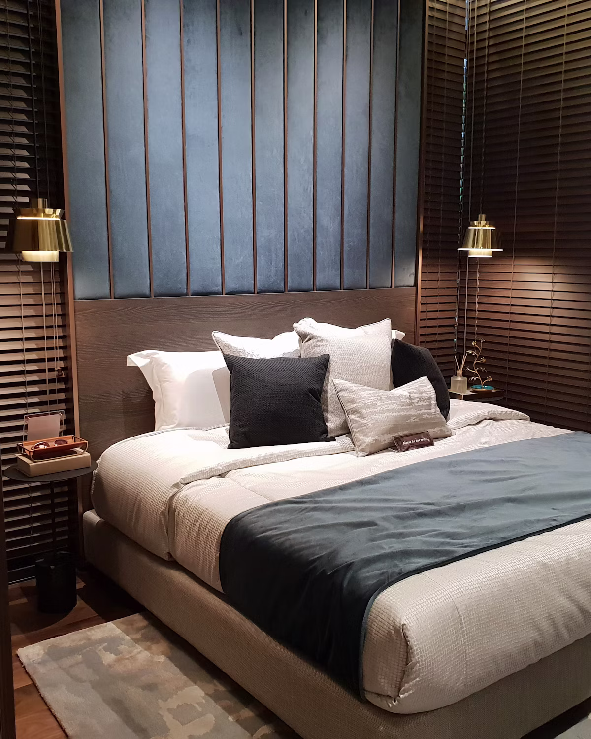 Warm wood-toned room with layered bedding and soft ambient lighting