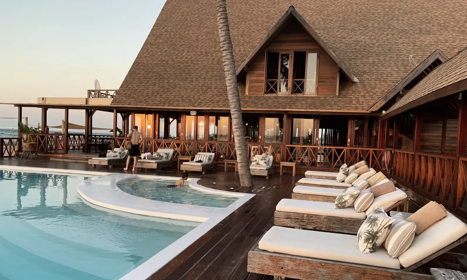 The Velvet Crest premium hotel with a softly lit poolside courtyard at dusk